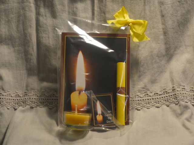 Geschenkig verpackte Faltkarte mit Kerzenmotiv, dazu eine Kerze und ein besinnlicher Text.