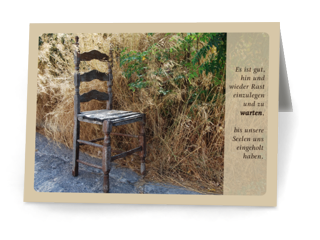 Ansicht der Klappkarte: Ein Stuhl steht am Rand einer Straße vor hohem Gras. Daneben der Spruch.